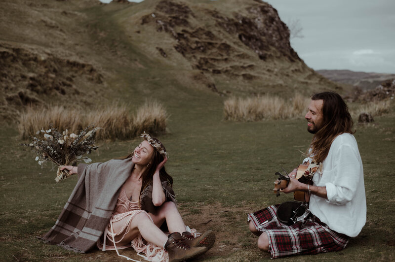 couple sitting on the ground at isle of skye