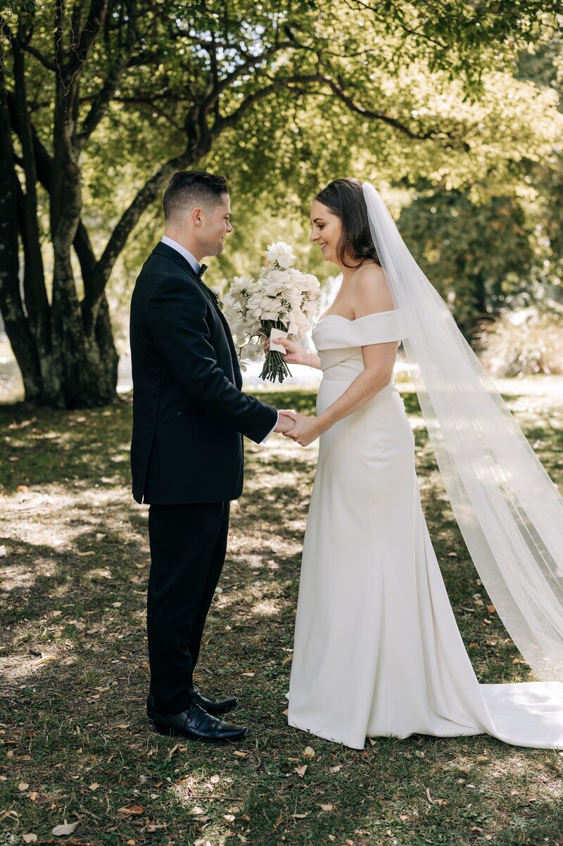 bride and groom in the queenstown gardens in the sunshine on their wedding day nz