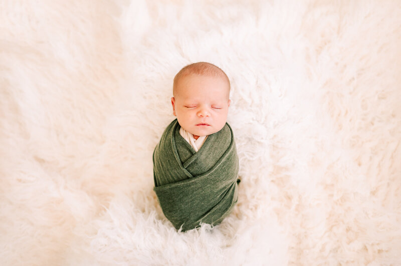 Springfield Mo newborn photography of newborn baby boy swaddled in green sleeping