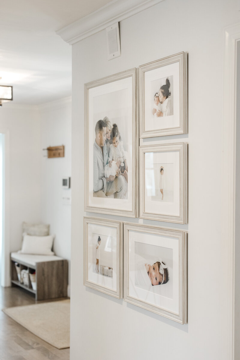 Framed family portraits hung on a home wall