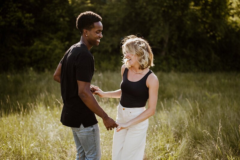 man and women dancing in field laughing