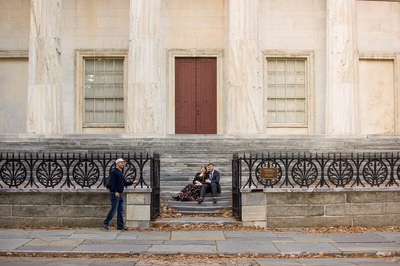 A behind-the-scenes moment of Travis Stitt guiding an engaged couple into a pose during an engagement session at Second Bank, capturing his hands-on approach and the timeless charm of the historic location.