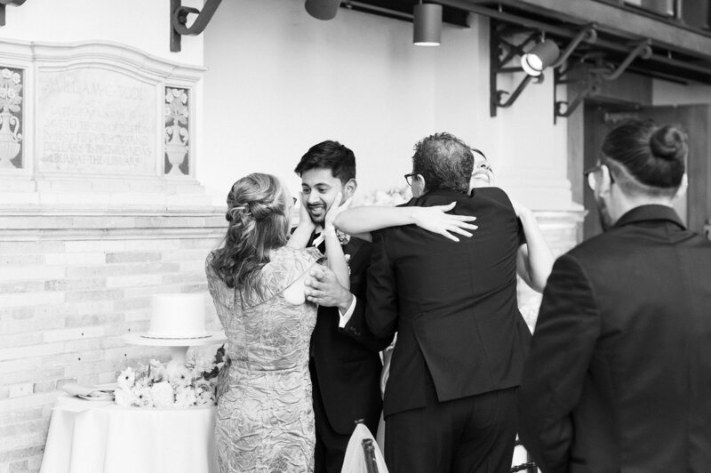 black and white of couple hugging parents during boston wedding rception
