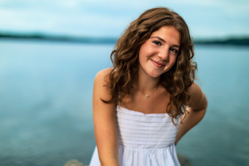 Smiling high school senior posing by the lake at Moraine State Park at sunset