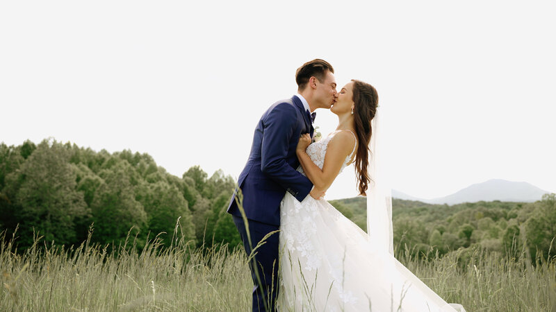 Couple Kisses In Field in Lynchburg Virginia Wedding
