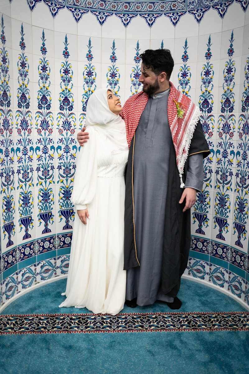 Couple in traditional attire smiling indoors