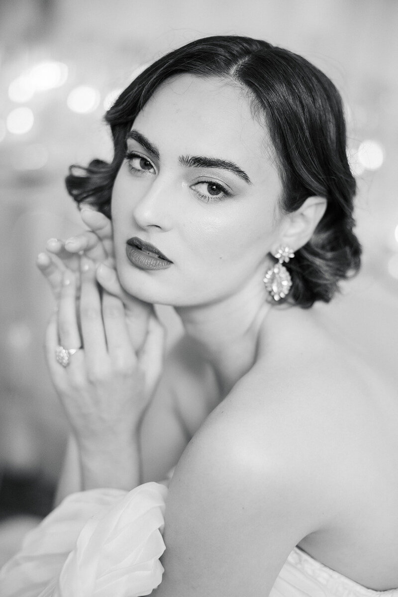 Regal classic brunette bride with short dark hair  and large ethereal engagement ring gazes intently 