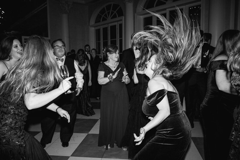 A bridesmaid dancing with her hair flying in the air. Photographed by Casey McMurray