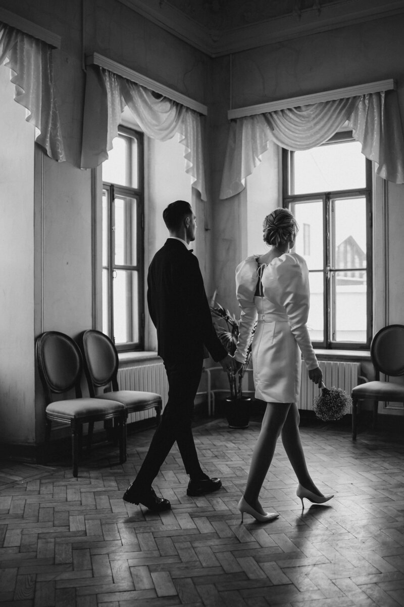 A bride and groom captured walking hand in hand in black and white, representing wedding inspiration at the bridal show.