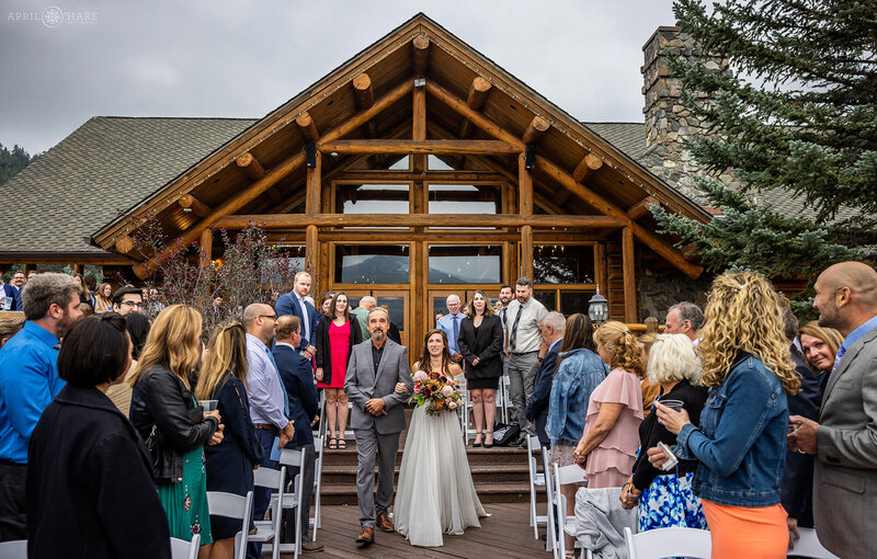 Bride Walks with her Dad down the stairs onto deck at Evergreen Lake House in Colorado