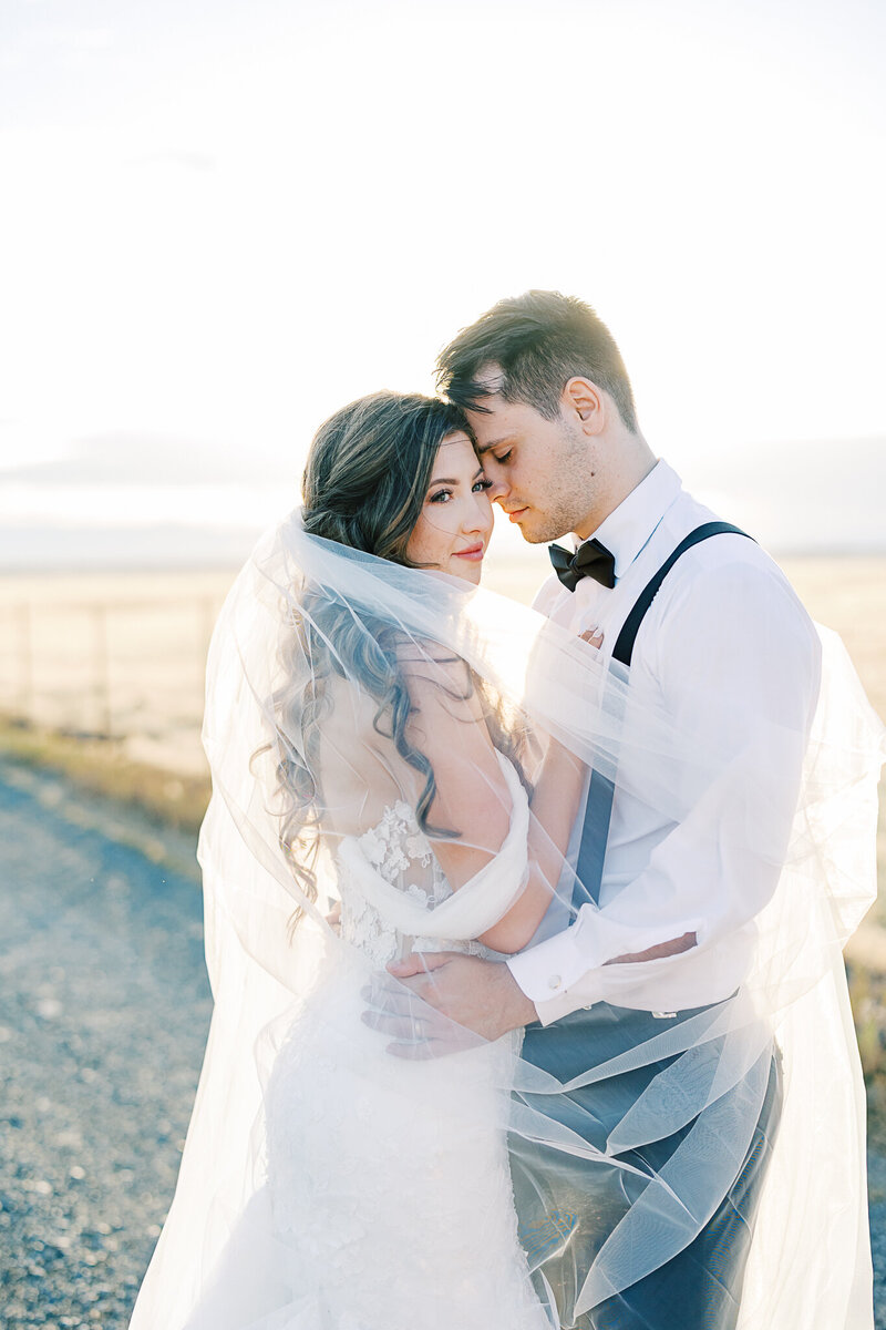Rustic wedding ceremony at White Ranch in Chico, California, featuring a bride and groom with scenic countryside views, golden fields, and charming rustic architecture.