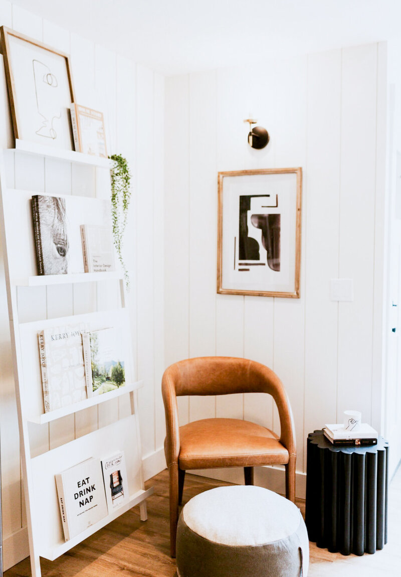 A nice leaning book rack and brown leather chair with cushy footstool in the corner of the white Whitebarn bridal suite.