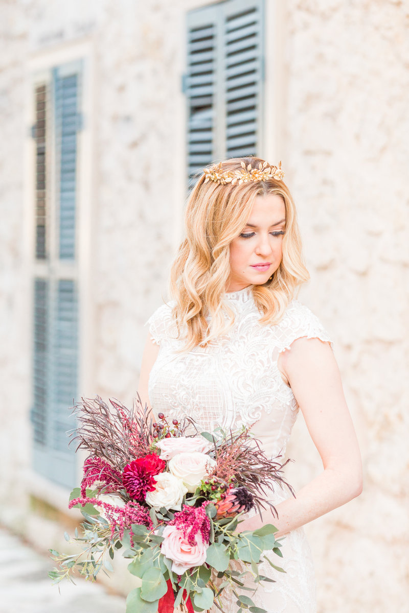 bride wearing a gold wreath around head and holding a floral bouquet designed by touch of whimsy