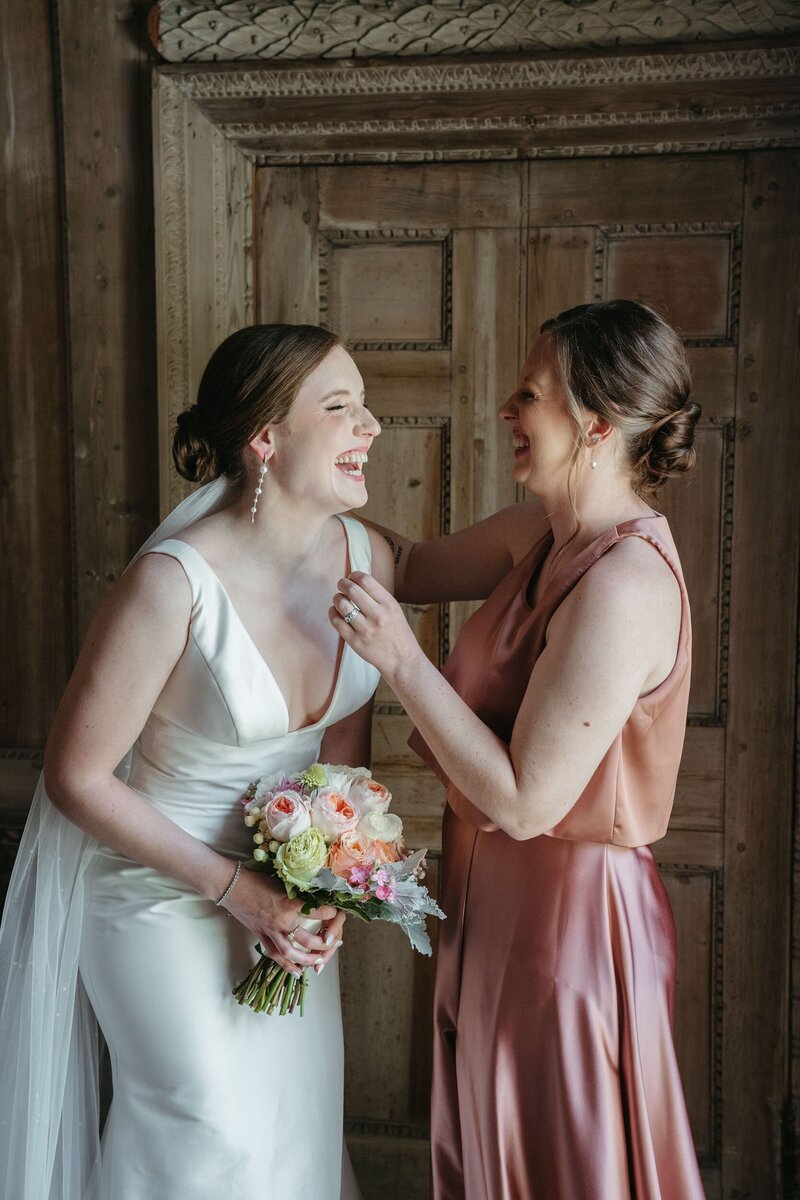 Bride laughing with bridesmaid