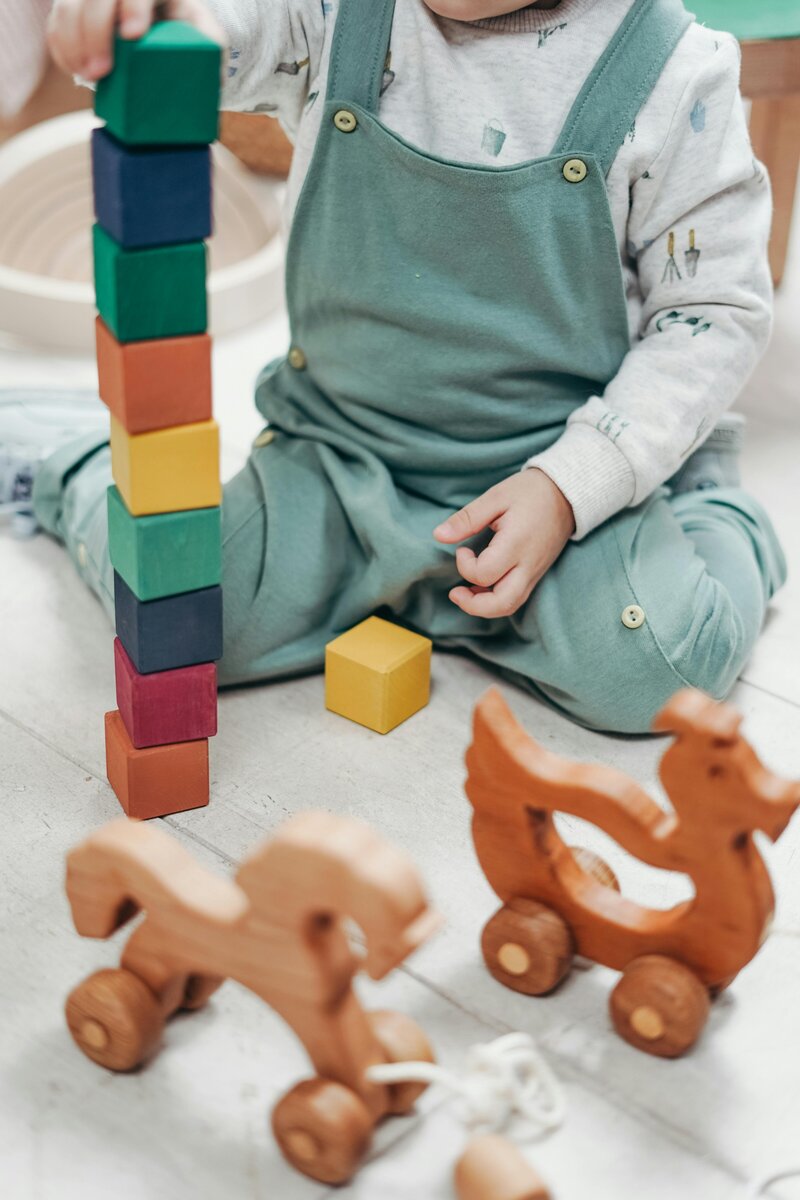 Childcare center photo of child playing with colourful blocks.