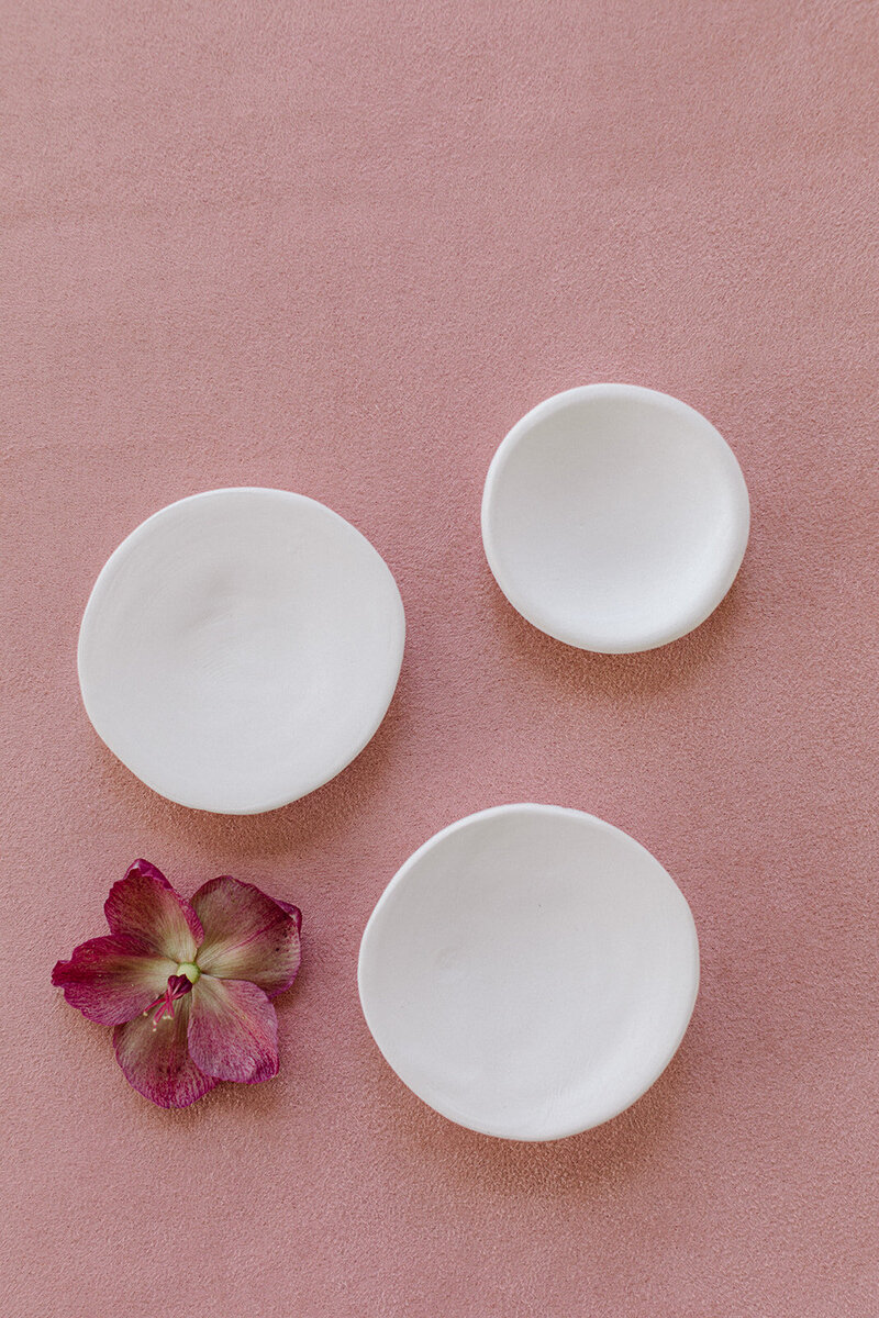 Handmade ceramic dishes used to organize accessories in flat lay photography