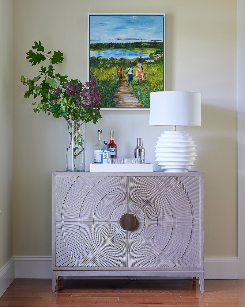 Elegant sideboard featuring a decorative white lamp, a potted plant, and intricate design details, adding a touch of sophistication to the space
