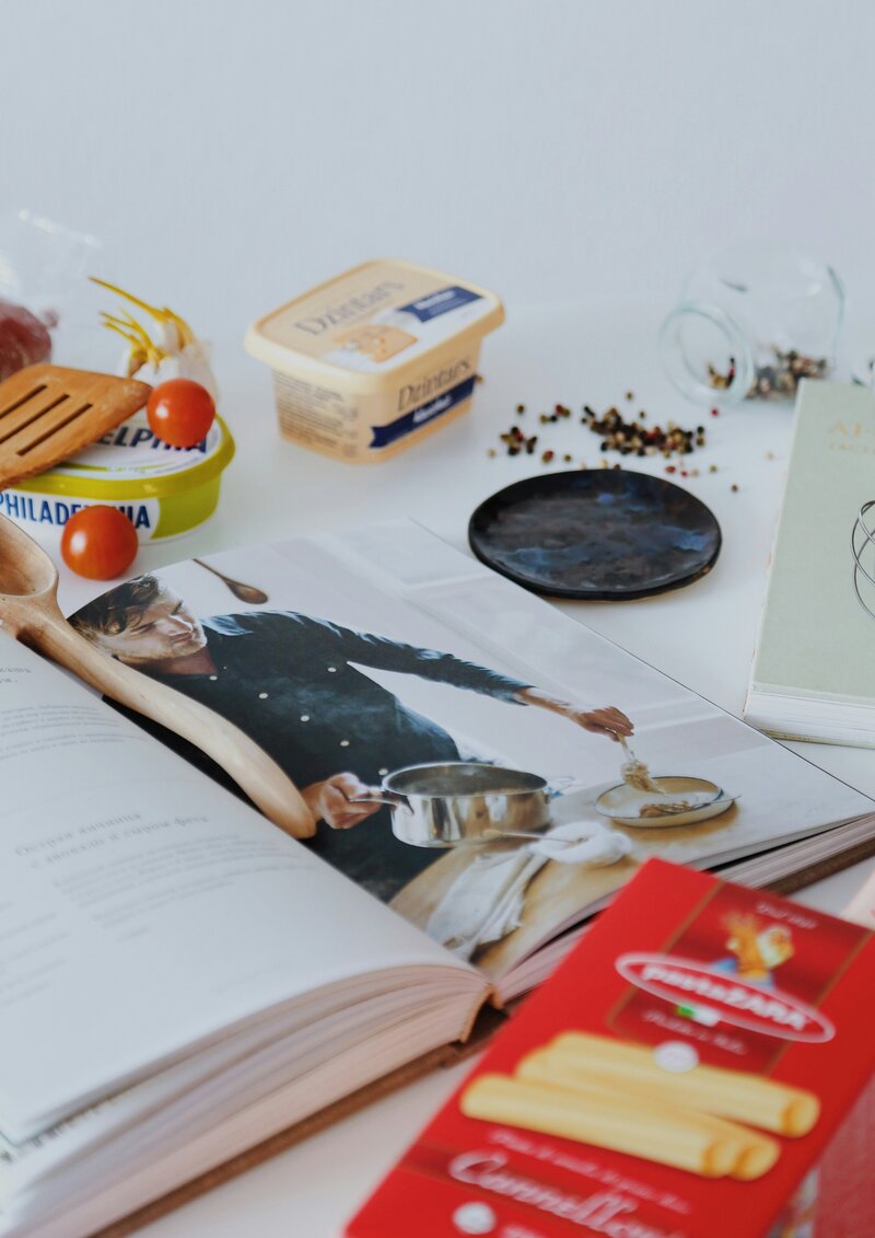 A cookbook and assorted ingredients laying on a countertop