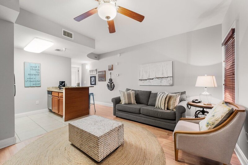 living room with grey couch and ceiling fan