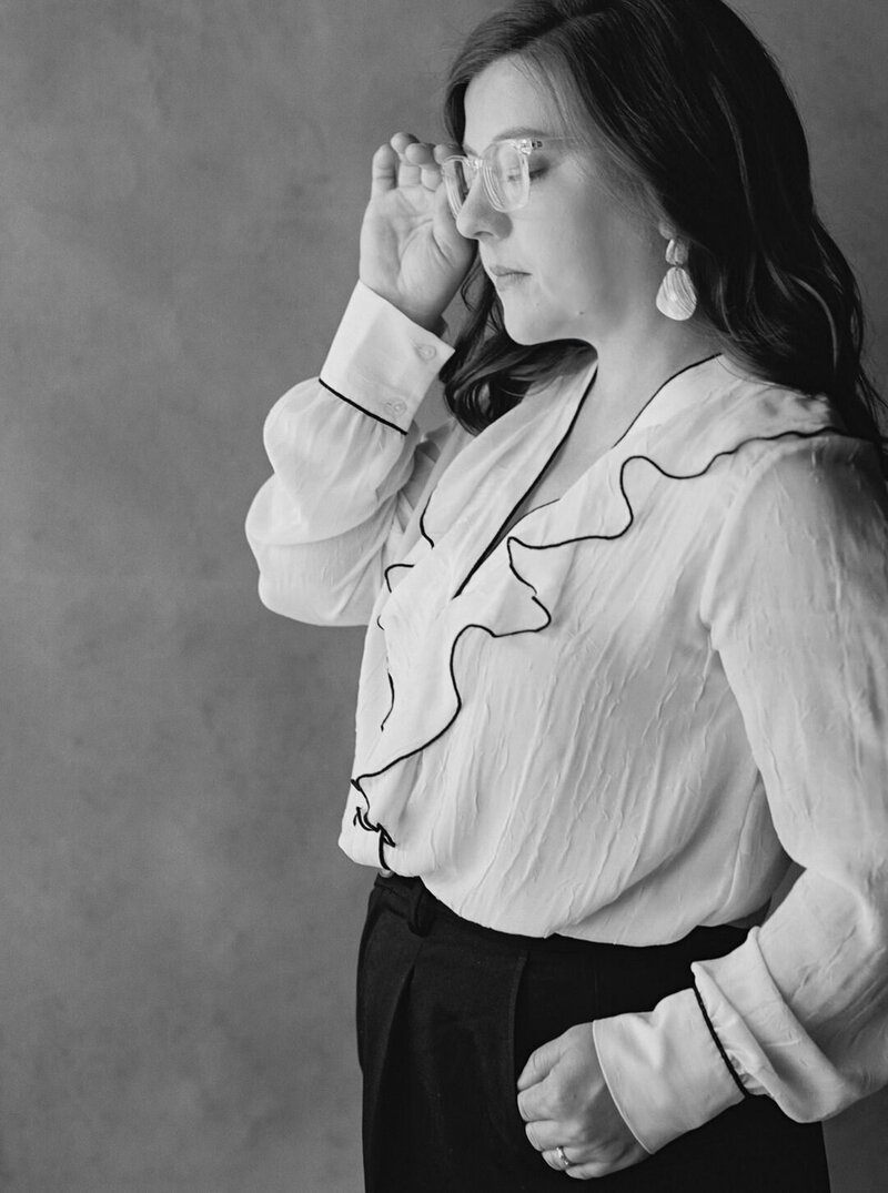 Black and White Photo of Wedding Photographer Tanya McSween Looking Down Holding Glasses