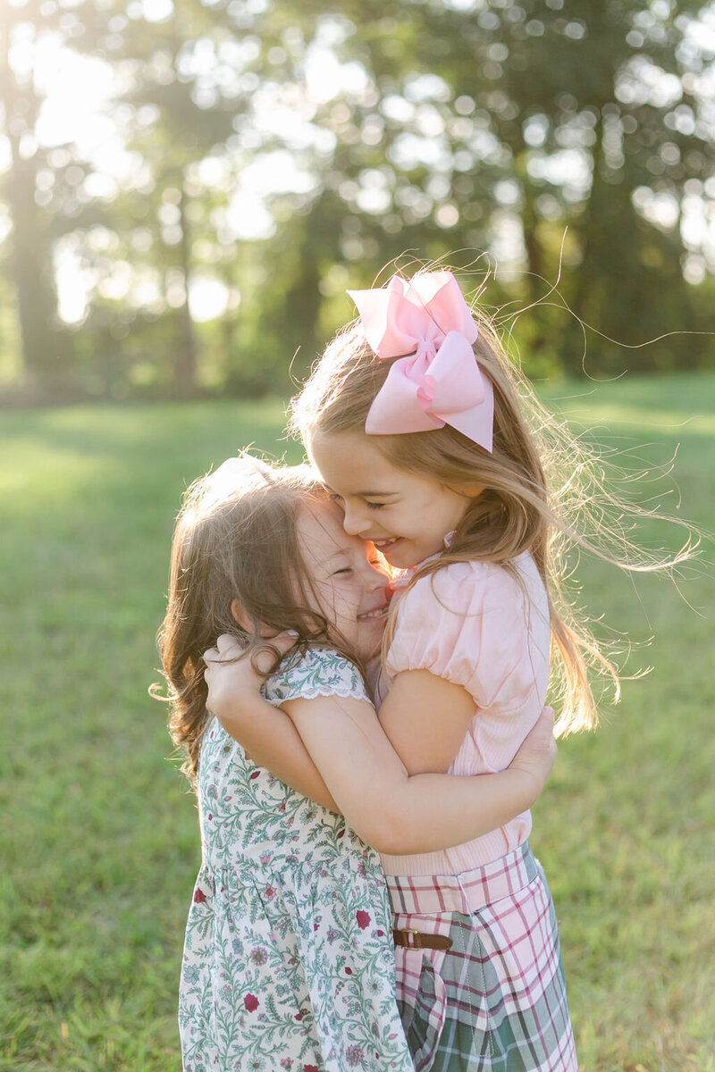 Two sisters embrace during a family portrait session by Rochester NY family photographer Emi Rose Studio.