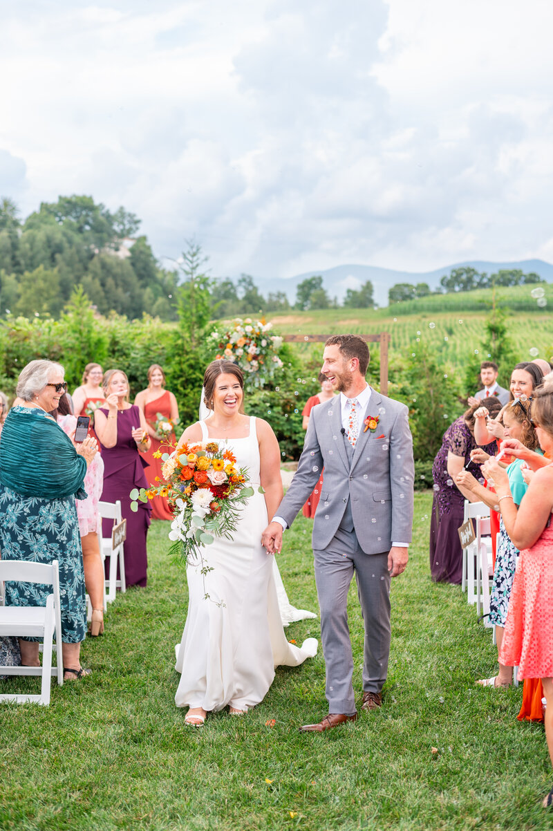 A wedding day shot of a bride and groom kissing with a lake and waterfall behind them.