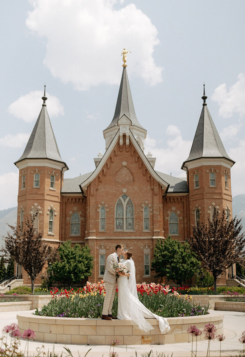 Bride and groom embracing in front of the Provo City Center Temple in Utah, captured by a wedding photographer.