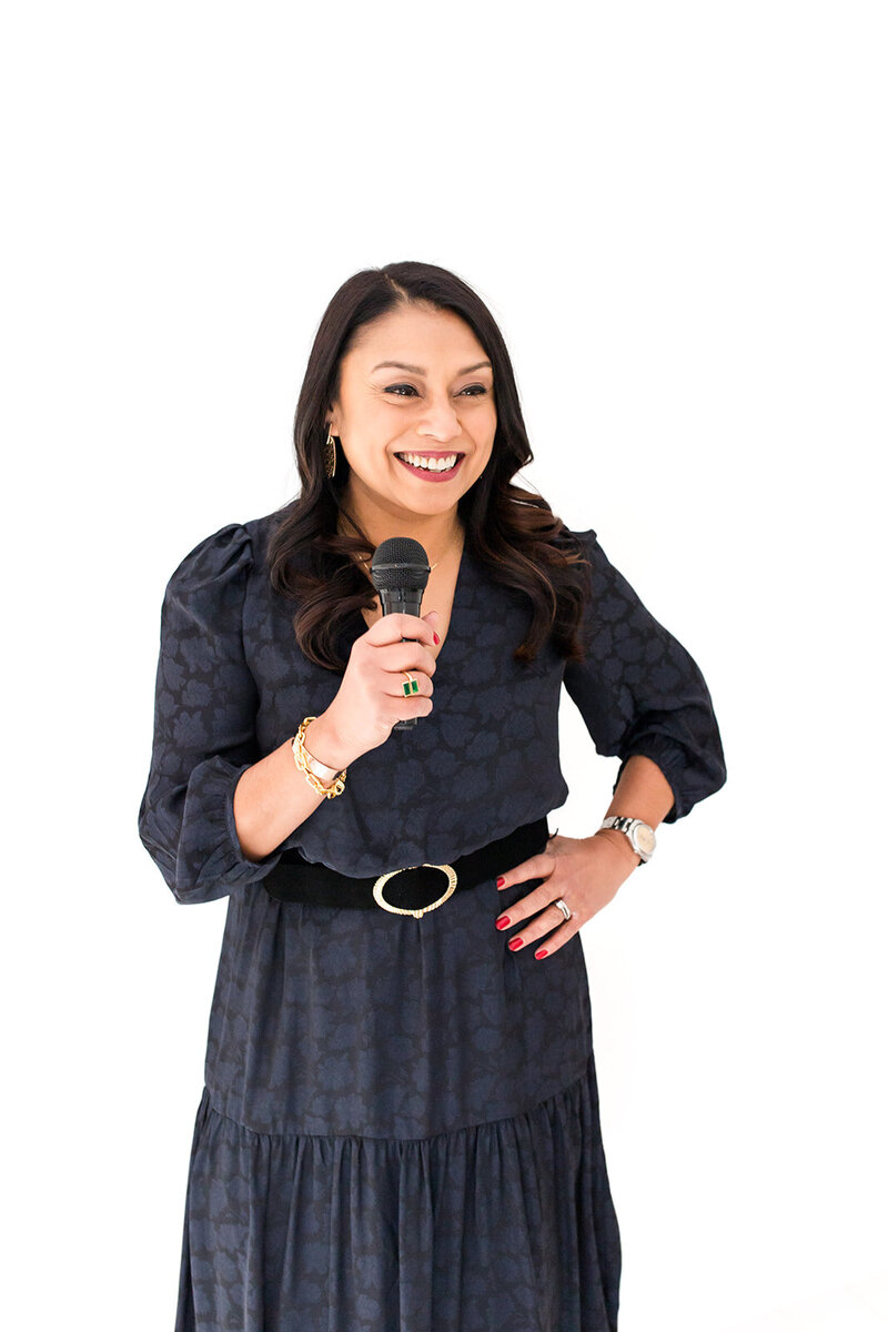 Mallika Malhotra holding a microphone, confidently speaking about key branding strategies for building a six-figure brand.