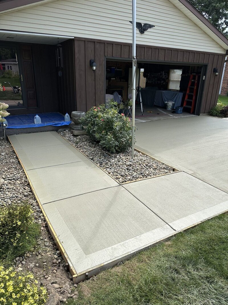 New concrete front walk and apron beside a stone bed in Goshen, IN