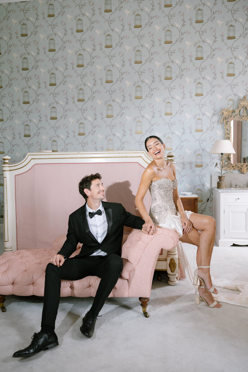 Bride and groom sat on pink sofa