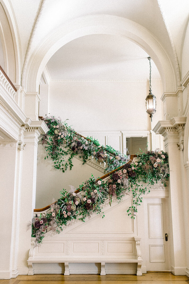 Tiffany Longeway Photography captures the stunning floral arrangements adorning the grand staircase at The Palace Hotel in San Francisco, California. The luxurious and historic charm of the venue, combined with the exquisite floral decor, creates a breathtaking setting, ideal for couples seeking a sophisticated and elegant wedding celebration.