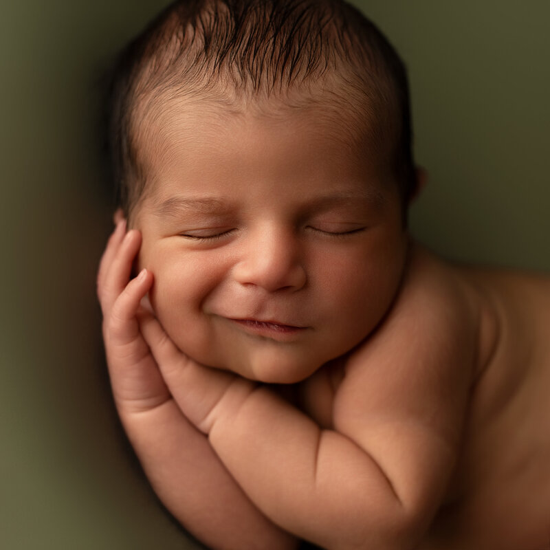 Smiling newborn portrait in warm rustic tones—highlighting the final call to action on our Paris, Ontario newborn photography portfolio page.