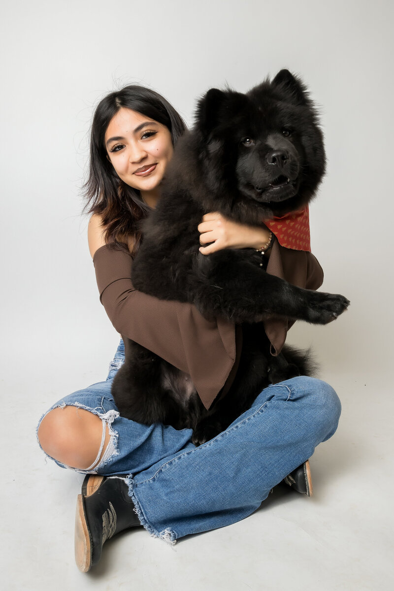 Young woman holds pet dog for modern pet portraits at Sacramento studio