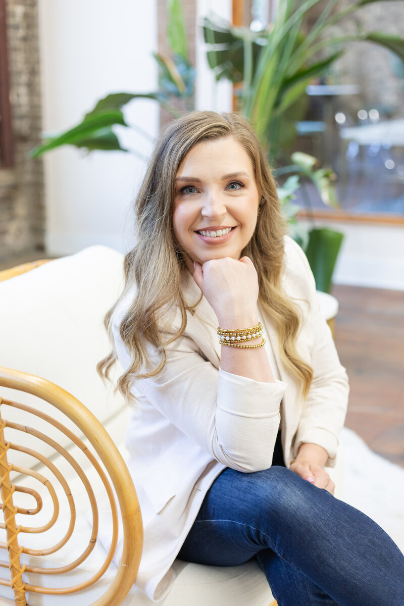 Erika sitting on a couch with her hand gently touching her chin