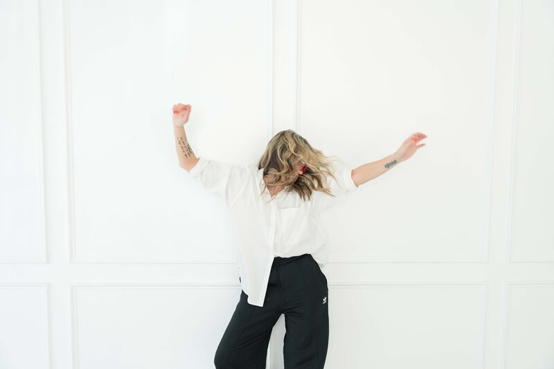 Brand and design expert dancing confidently to empower small businesses to showcase their powerful voice.