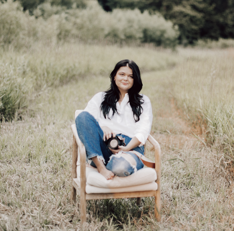 woman sitting in chair with camera