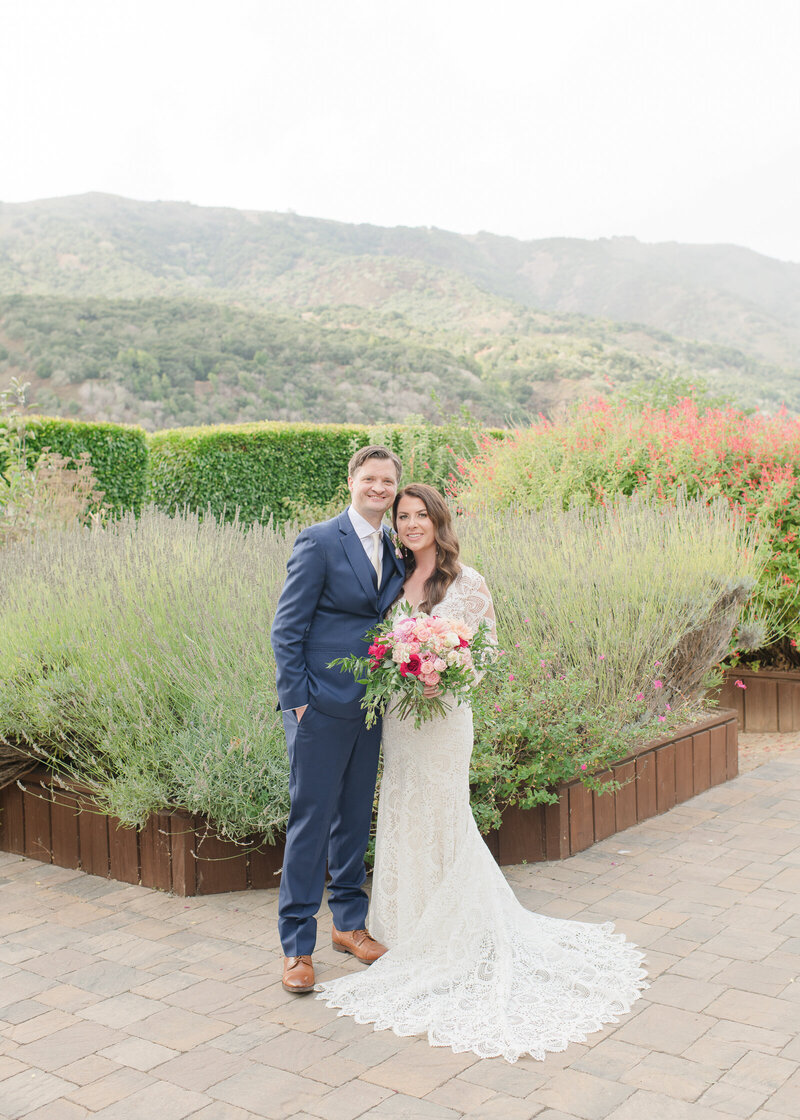 couple facing the camera and smiling at their garden wedding
