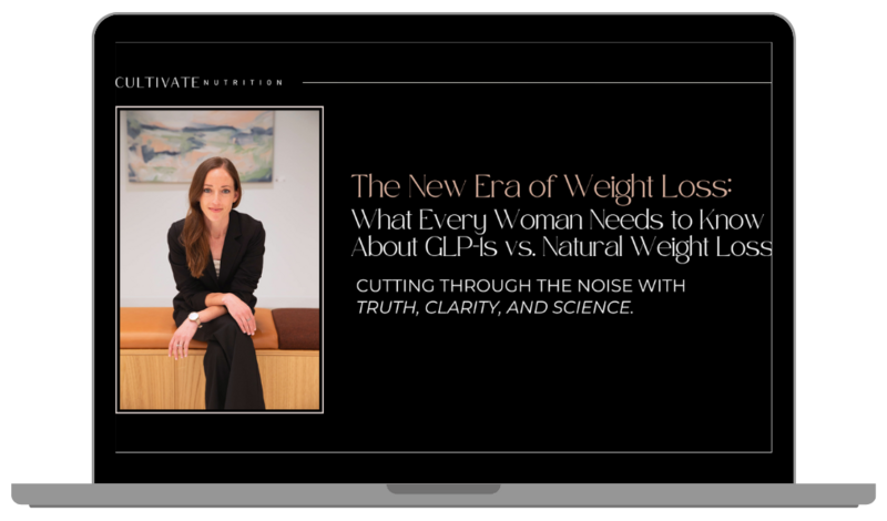 Image of a plate of figs sitting on top of a magazine. The sun is casting shadows across the table as the light shines through a glass filled with a drink.