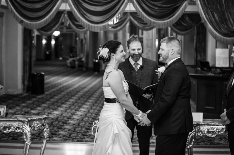 Erie couple hold hands during their Warner Theatre wedding ceremony