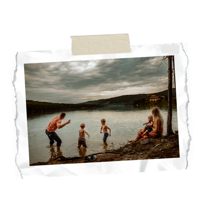 family skipping rocks on lake