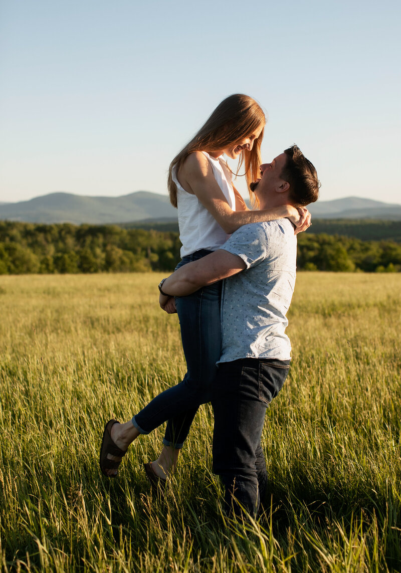 Eric holding Liz up romantically in a field 