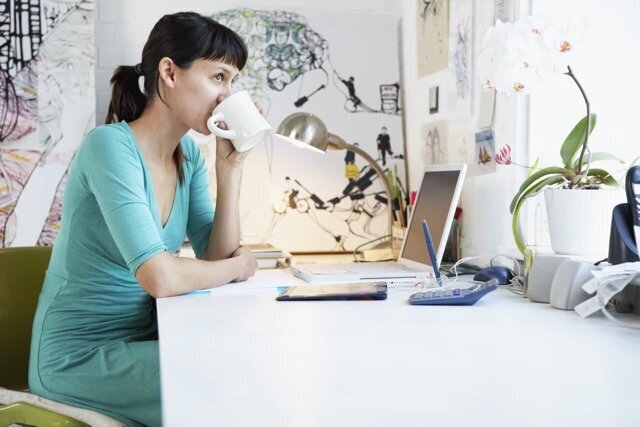 Female author using editorial services, working on manuscript editing at desk with laptop