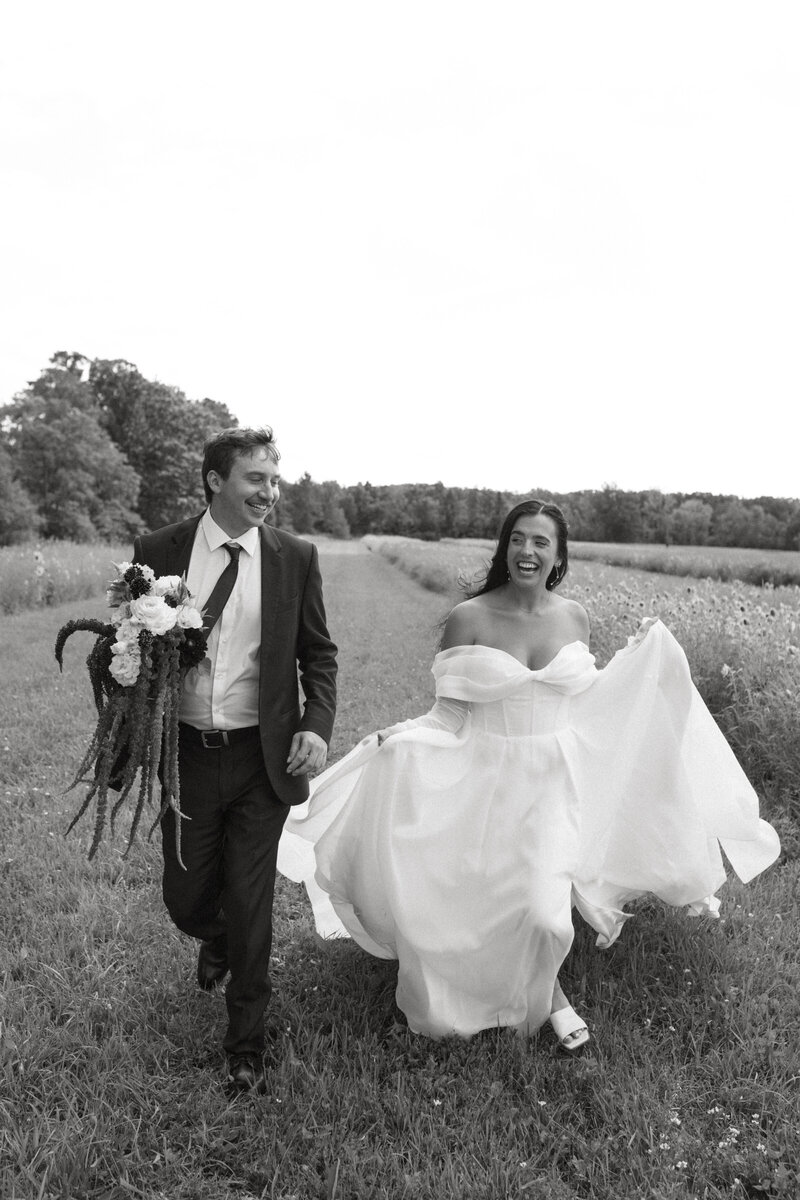 Bride and groom running through field – documentary wedding photographer New York