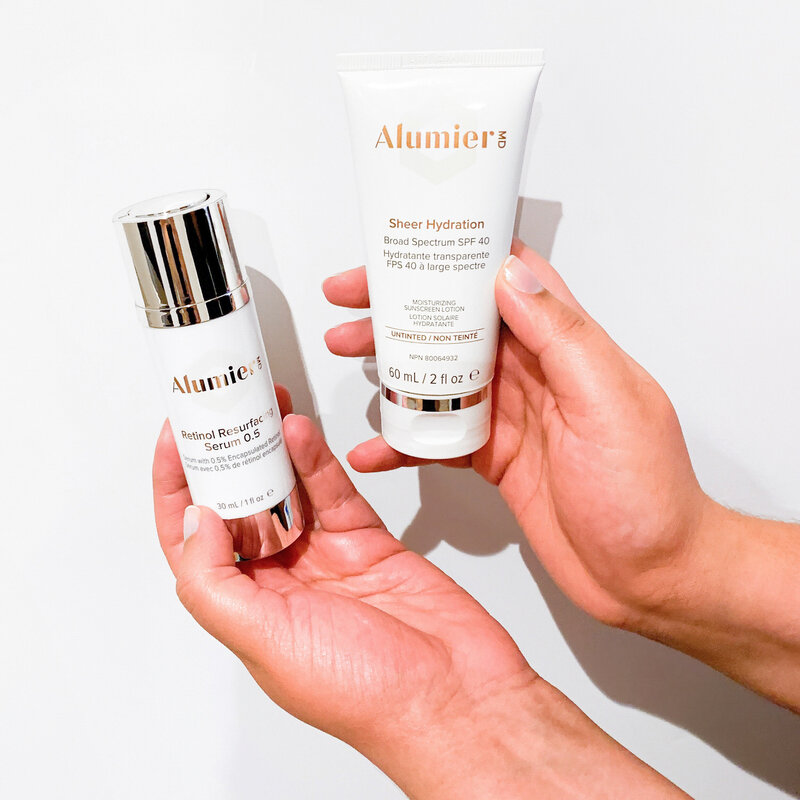 AlumierMD skincare products in hand