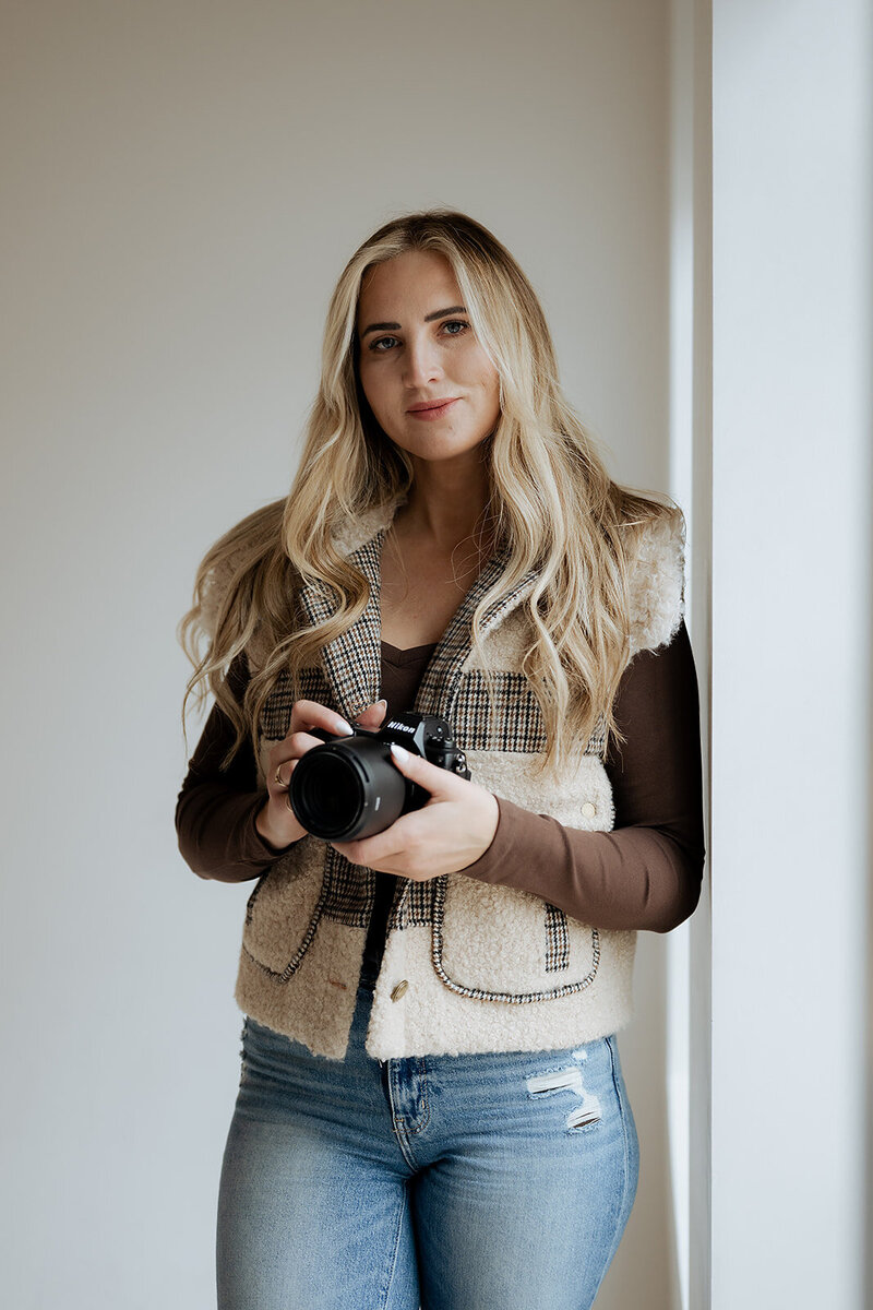Meet Becca a Utah elopement photographer that is a specialist in Yosemite elopements. Becca is wearing a cowgirl hat and holding her camera that she takes amazing photographs with.