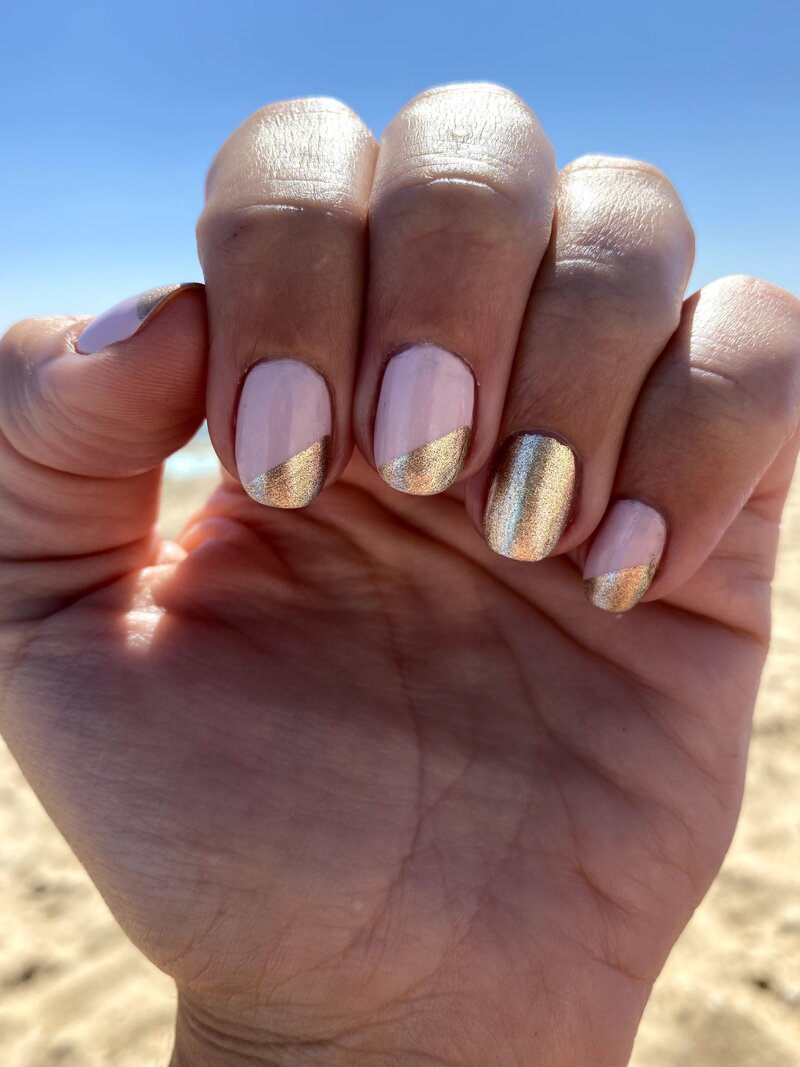 pink and gold metallic nail polish on female hand