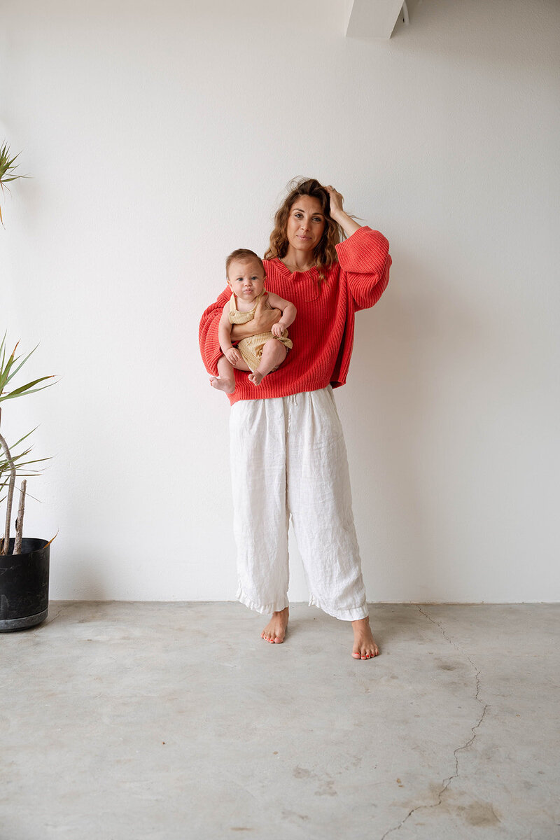 Lifestyle newborn photography in Orange County featuring a mother and baby in soft natural light.