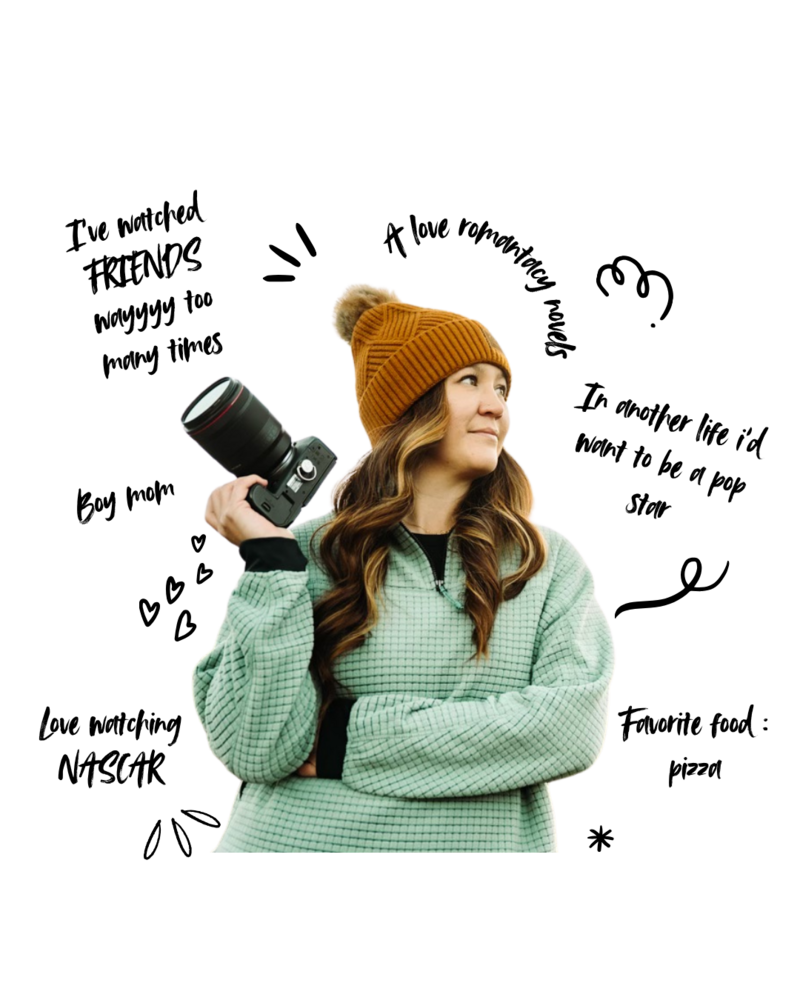 woman holding up a camera and smiling with an arm full of tattoos