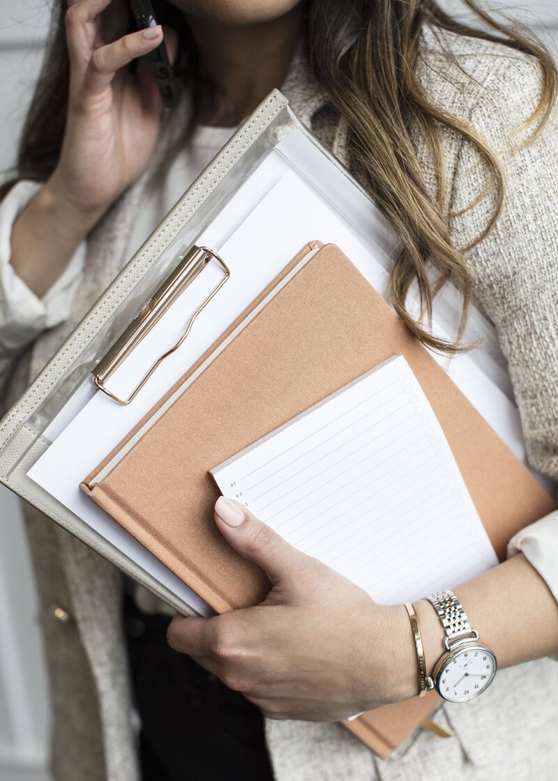 Business woman on the phone holding a clip board