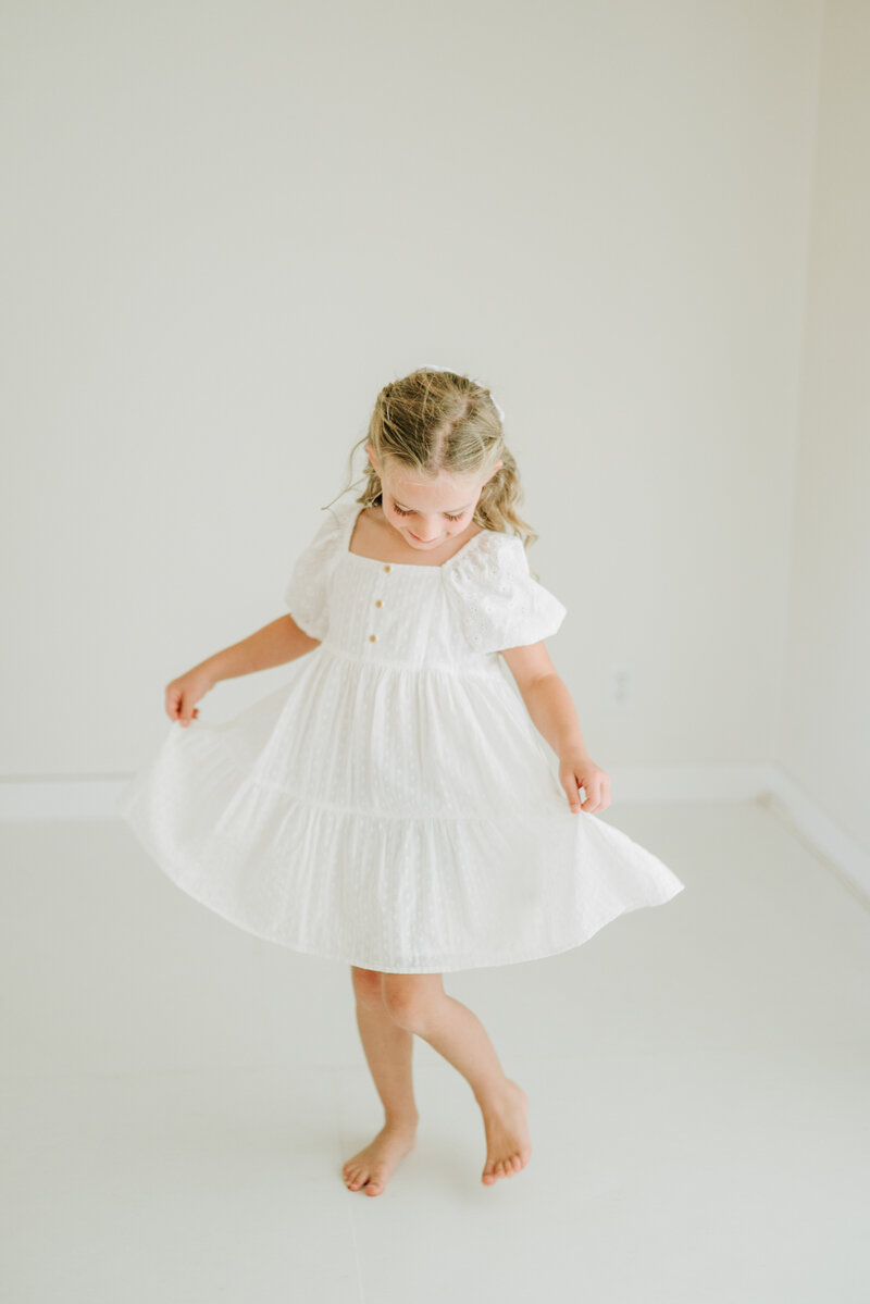 Little girl dances at Cayton Heath Photography's portrait studio. Light and airy children's portraits in Redding California and Norther California